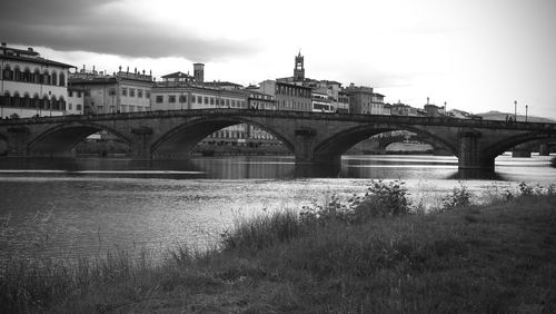 Arch bridge over river against sky