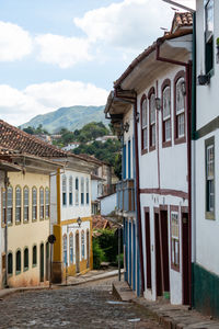 Houses by street in town against sky