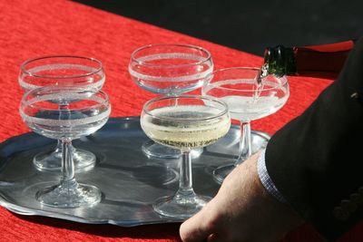 Close-up of hand holding wine glasses on table