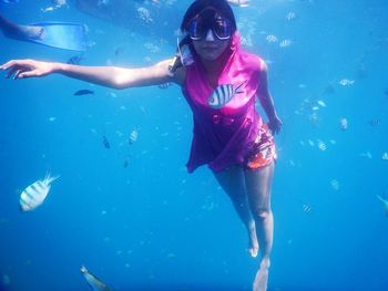 Portrait of young woman swimming underwater