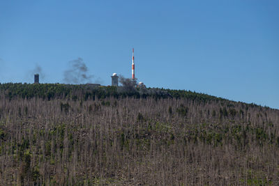 Low angle view of factory against clear blue sky