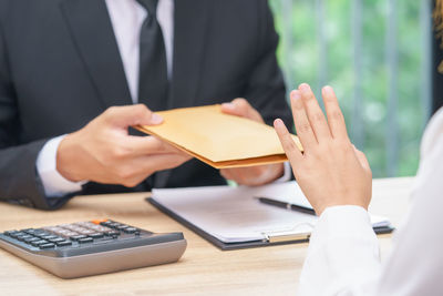 Midsection of man holding flowers in table