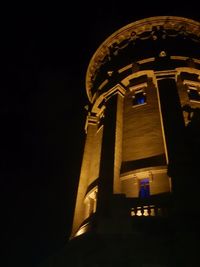 Low angle view of illuminated building against sky at night