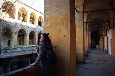 Woman standing in old corridor