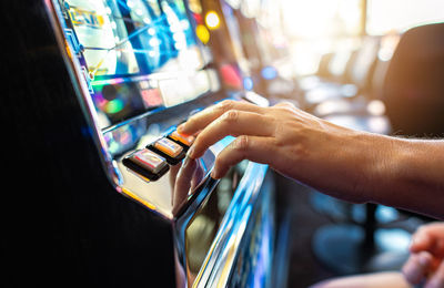 Woman playing classic slot machine inside las vegas casino. one handed bandit game play. 