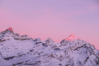 Scenic view of pink mountain against sky during winter