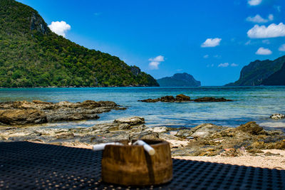 Cigarette stubs on an ashtray in front of a view of el nido bay