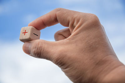 Low angle view of person holding hands against sky