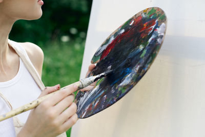 Midsection of woman holding multi colored umbrella