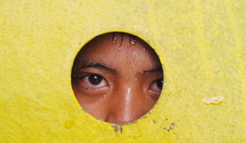 Portrait of wet person peeking through hole