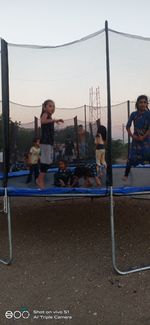 People playing in playground against sky