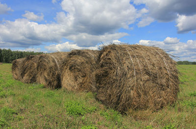 Hay bales on field against sky