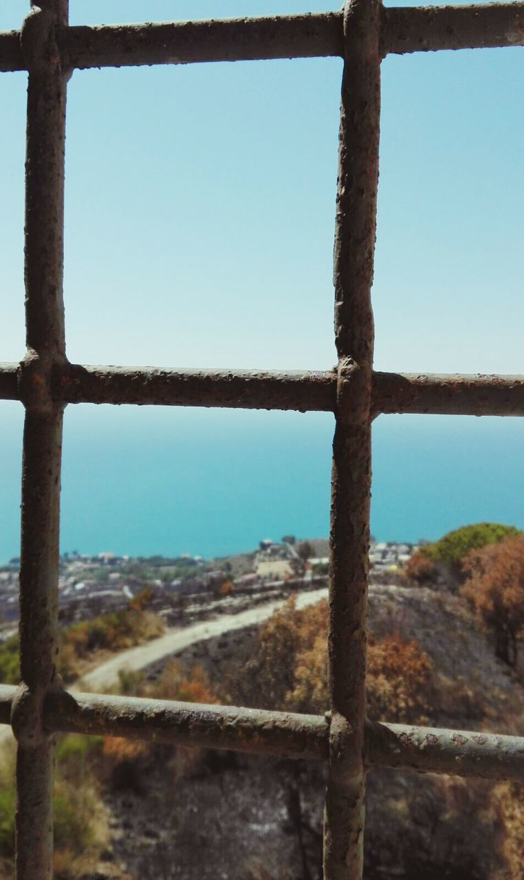 CLOSE-UP OF OLD WINDOW AGAINST SEA