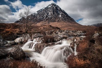 Scenic view of waterfall against sky
