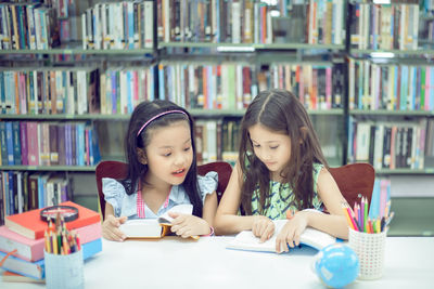 Portrait of a smiling young woman reading book