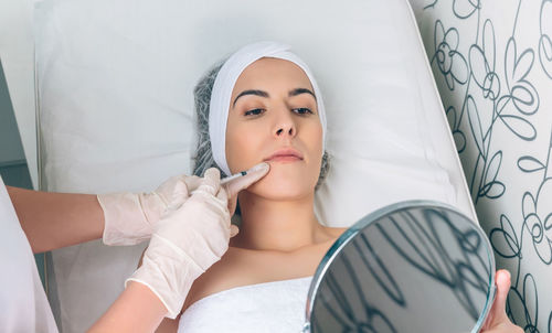 Midsection of woman lying on bed