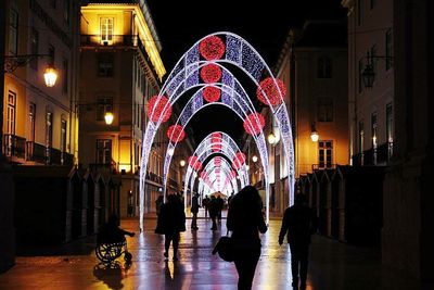 People walking in illuminated city at night