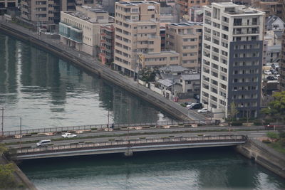 High angle view of bridge over river by buildings in city