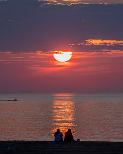 The golden sun rising beyond the ocean's horizon.