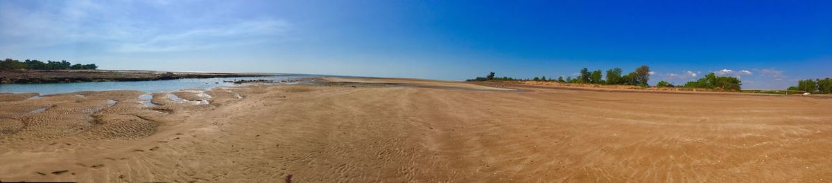 Scenic view of beach against blue sky