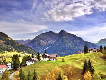 Scenic view of houses and mountains against sky