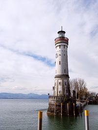 Lighthouse by sea against sky