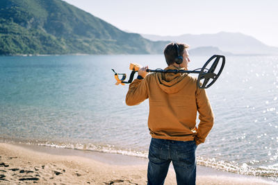 Rear view of man standing at beach