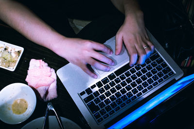 High angle view of woman using laptop typing keyboard