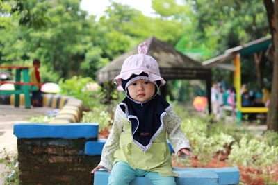 Portrait of young woman sitting in park