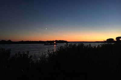 Scenic view of lake against clear sky during sunset