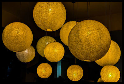 Illuminated lanterns hanging in darkroom