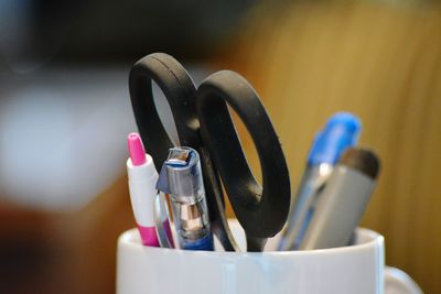 Close-up of pen and scissors in desk organizer