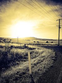 Fence on field at sunset