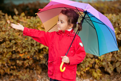 Portrait of happy girl holding umbrella