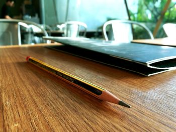 Close-up of pencil and menu card on table at restaurant