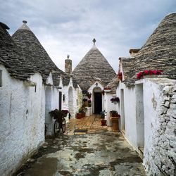 Rear view of old buildings in city against sky