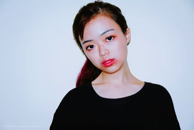 Portrait of young woman against white background