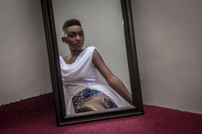 Young woman reflecting on mirror at home