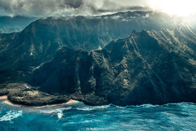 Scenic view of sea and mountains against sky