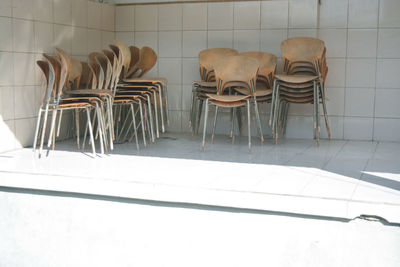 Empty chairs and table against wall