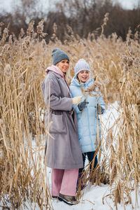 Woman with umbrella on field during winter