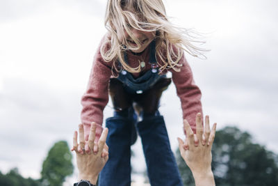 Cheerful daughter playing with father outdoors