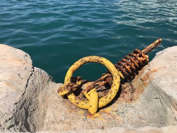 High angle view of rusty metal tied on rock