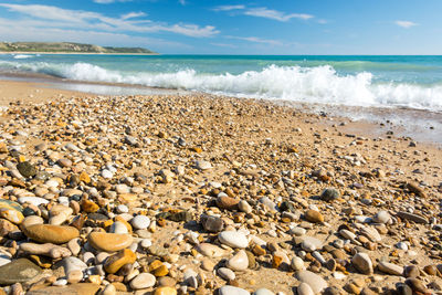 Pebbles on beach against sky