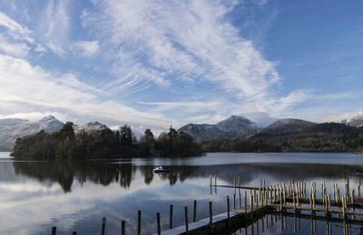 Scenic view of lake by mountains against sky