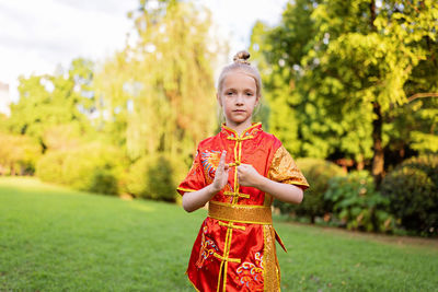 Portrait of young woman standing on field