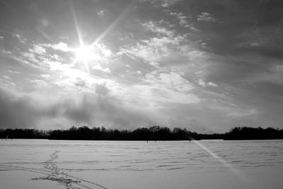 Scenic view of snow field against sky during winter