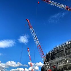 Low angle view of crane against blue sky