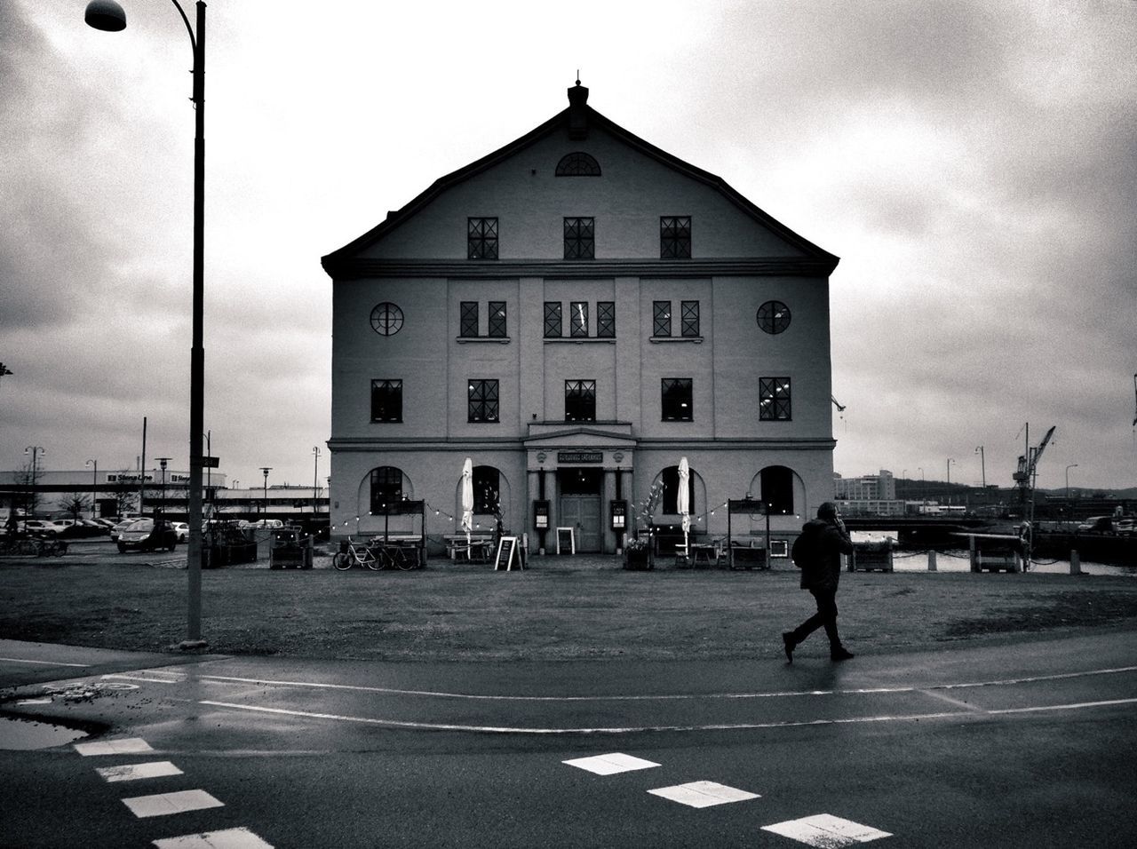 building exterior, architecture, built structure, street, transportation, sky, road, city, men, walking, road marking, street light, city life, mode of transport, cloud - sky, car, incidental people, lifestyles