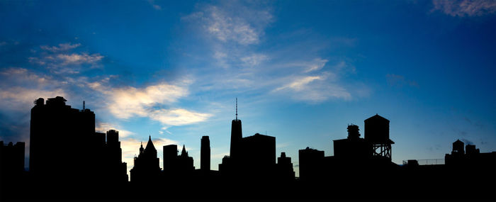 Silhouette of buildings against cloudy sky